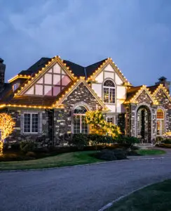 house yellow lights trees trim